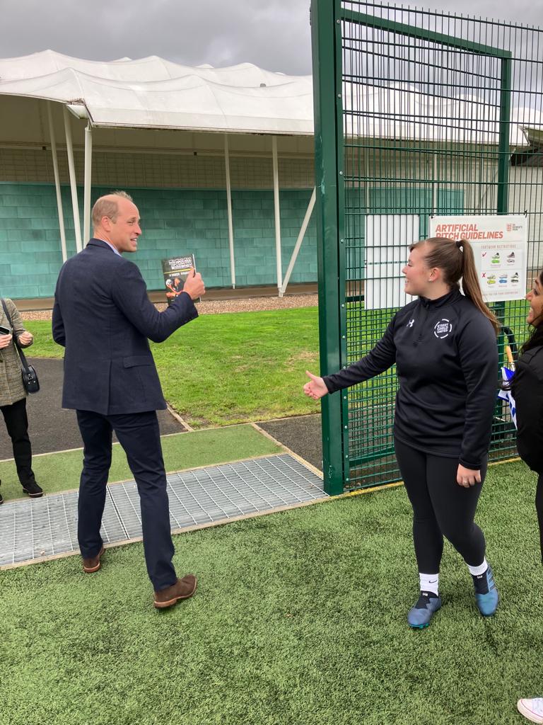 SCU YL Sam Richards hands Prince William a copy of her book 'We are Somebody'